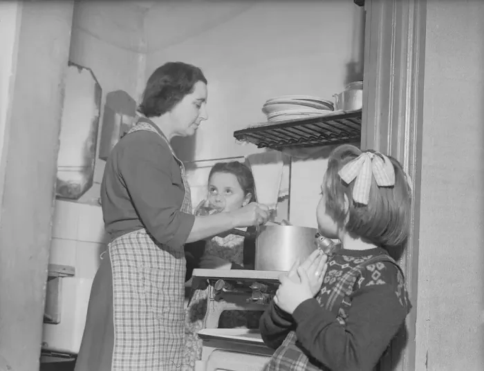Framed Print : Stay at home mother Mrs Mary Mackenzie seen preparing the evening meal being watched by