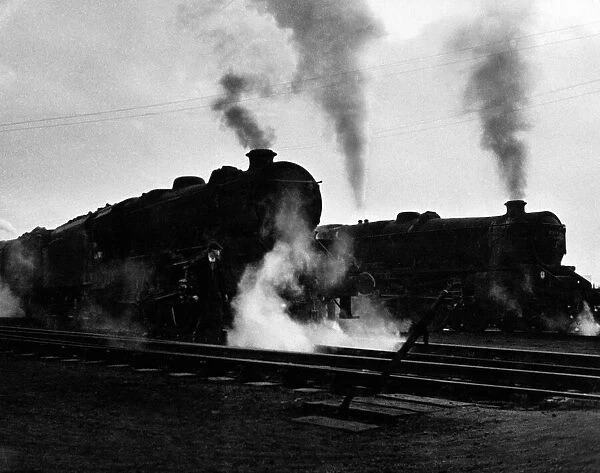 Steam locomotive engines steaming up on the tracks near Birmingham, circa 1960