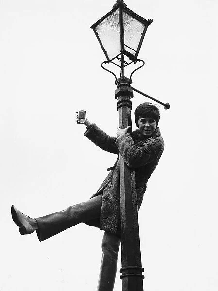 Stephanie Powers Actress hanging on lamp post with drink in hand Circa 1970