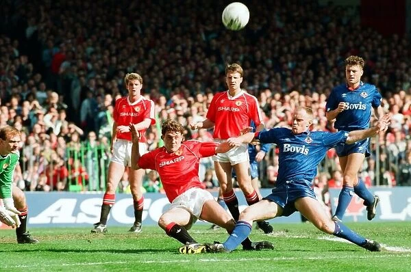 Steve Bruce tries to keep out Andy Ritchie. FA Cup. Manchester United 3 v Oldham Athletic