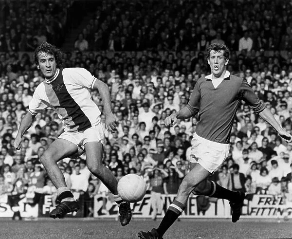 Steve Kember of Crystal Palace lays the ball off before Alan Gowling of Manchester United