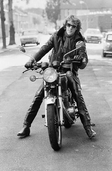 Stewart Copeland, drummer with the rock group, The Police, pictured on his motorbike