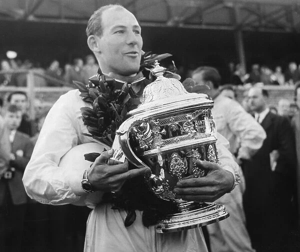Stirling Moss holding trophy wearing wreath celebrating motor racing victory - April 1958