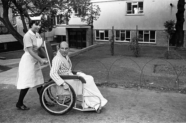 Stirling Moss, pictured in a wheelchair being pushed by a nurse