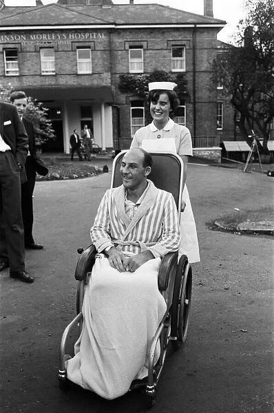 Stirling Moss, pictured in a wheelchair being pushed by a nurse