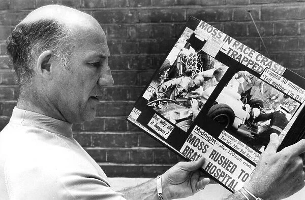 Stirling Moss reading clippings of his crash during race - August 1982