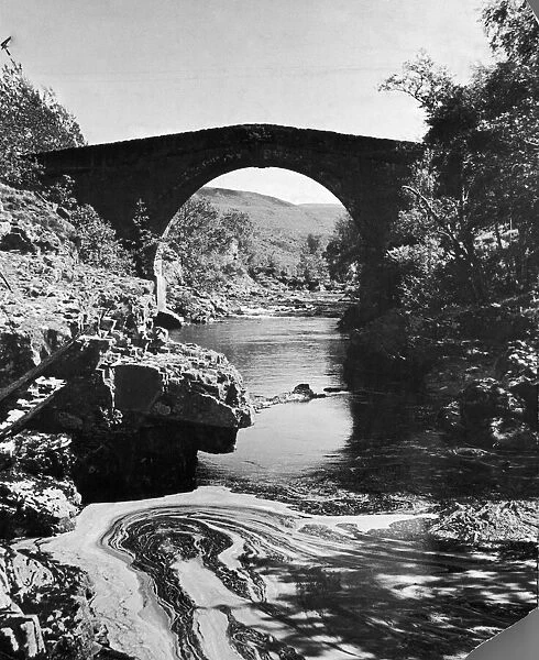 A stream passing underneath a stone bridge in rural Invernesshire, Scotland