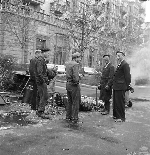 Street cleaners take a cigarette break while at work in one of the residential streets in