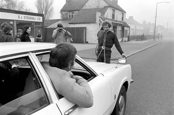 Strongman Reg Morris pulls car and passengers with his teeth. February 1975 75-00777