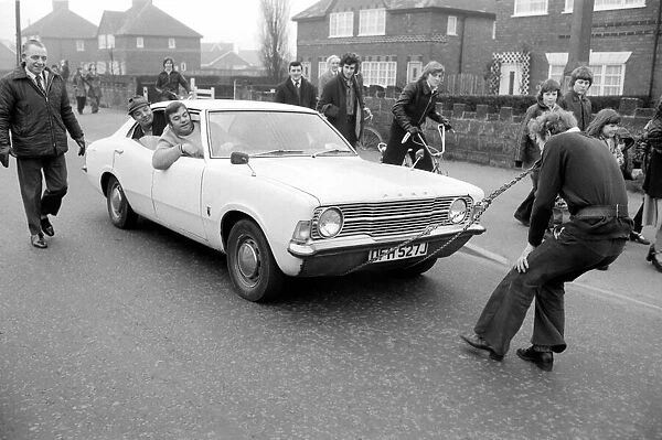 Strongman Reg Morris pulls car and passengers with his teeth. February 1975 75-00777-002
