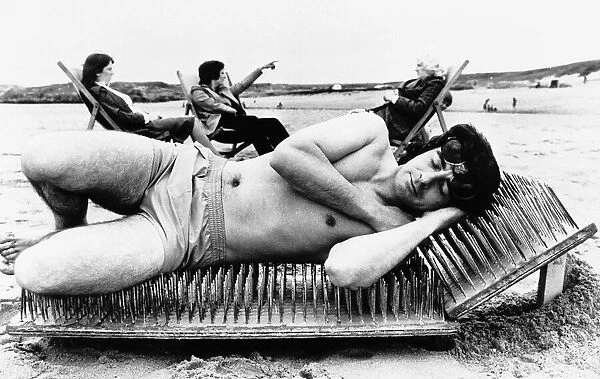 Stunts man lies on sunbed of nails on the beach Unknown date