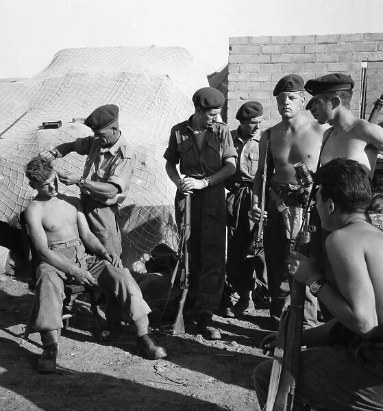 Suez Crisis 1956 Brigade Sergeant Major Ernest Lambert cuts the hair of Gunner Jim