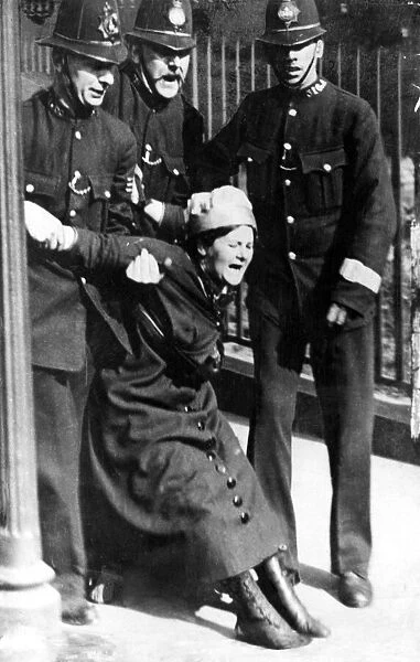 A Suffragette being restrained by three policemen. Circa 1912