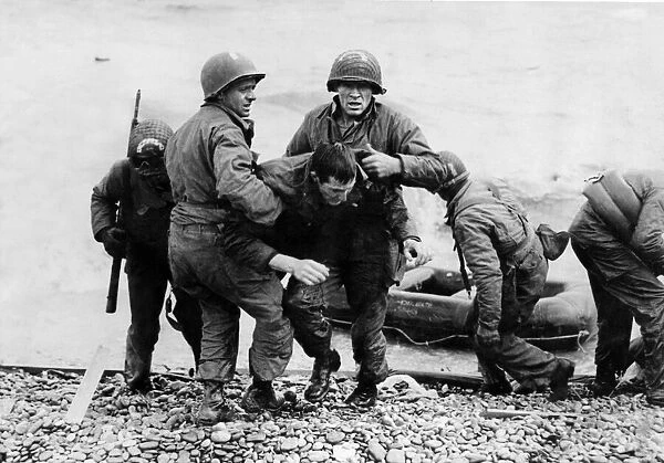 A survivor from a sunk American landing craft is helped ashore on Omaha beach, Normandy
