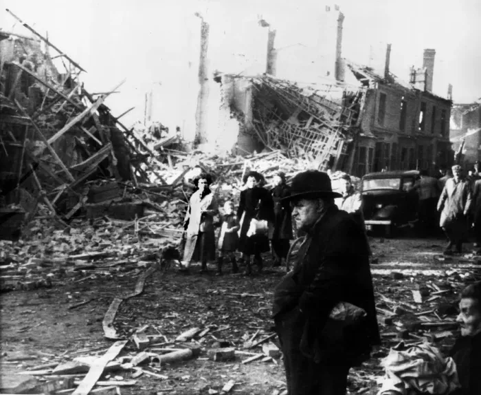 Framed Print : Survivors from the previous nights bombing seen here walking through the wreckage of