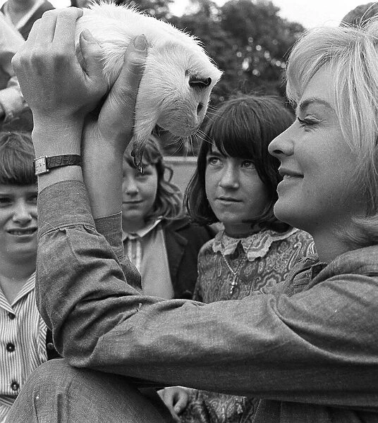 Susannah York with pet guinea pig and children on the set of the film Scruggs