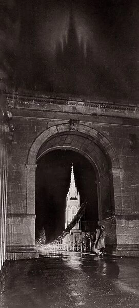 Through the suspension bridge arch under which two girls shelter All Saints Church at