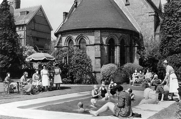 Swimmers laze in the sun by the outdoor pool at Rubery Hill Hospital, Birmingham