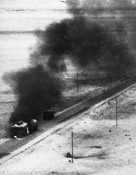 A tanker and trailer on fire after an attack from a Blenheim bomber during Second World