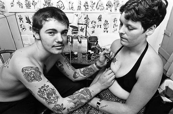 Tattooist John Taylor, 16, from Kings Lynn tattooing Della Gilbert, 20. 1st July 1978