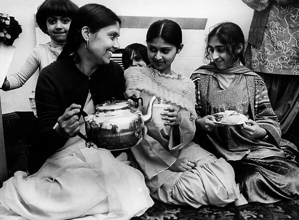 Some tea and cakes in the English style are served to a group of Pakistani women at
