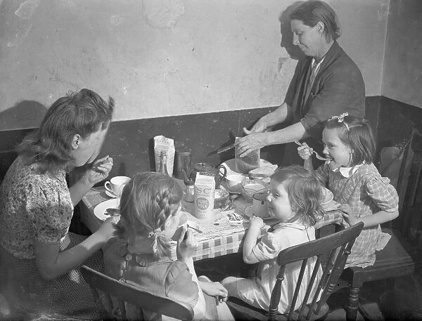 Tea time. The family gather around the kitchen table for a tea time meal. September 1946