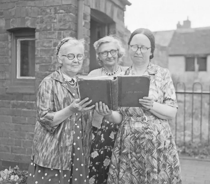 Framed Print : Three teachers looking over the log book at Hawkesbury Church of England School