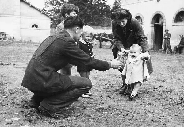 Teaching the baby to walk in the grounds of the camp for refugees in Normandy