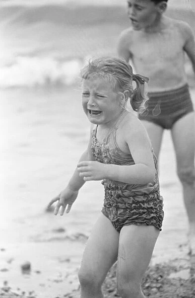 Tears for this young girl as she goes for a paddle in the sea on the beach at Brighton