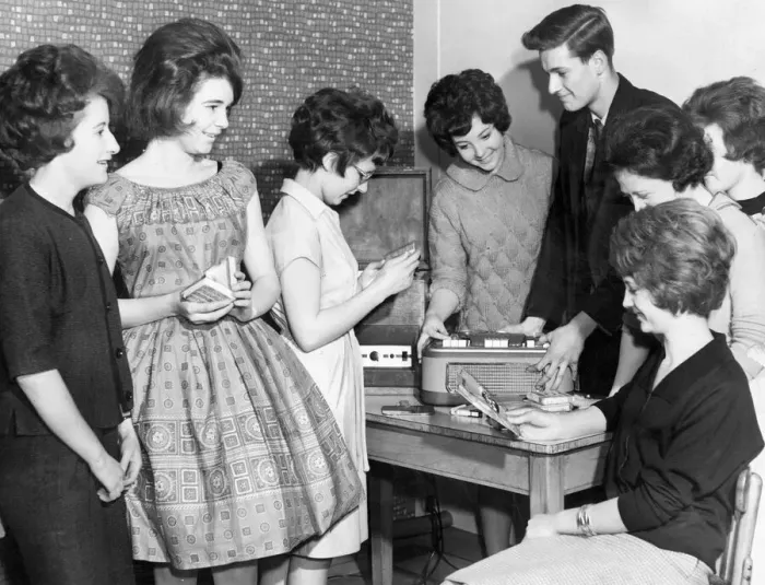 Framed Print : Teenagers crowd around the tape and record player at their local youth club