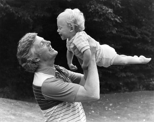 Television presenter Michael Aspel playing with his son Patrick