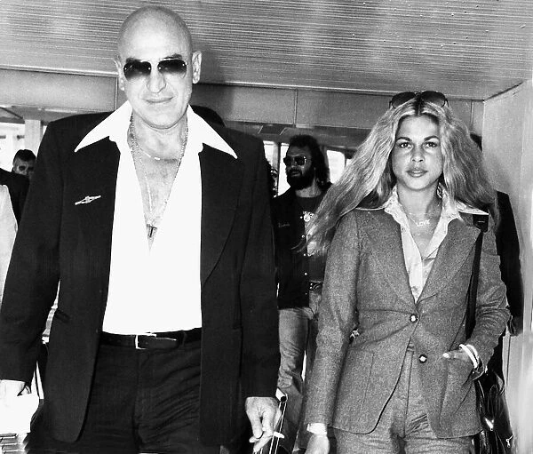 Telly Savalas film actor and girlfriend Sally in airport circa 1976