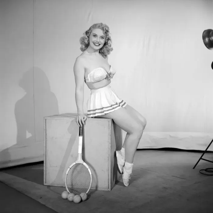 Framed Print : Anyone for tennis? Woman wearing bra, skirt holding tennis racket. 1959