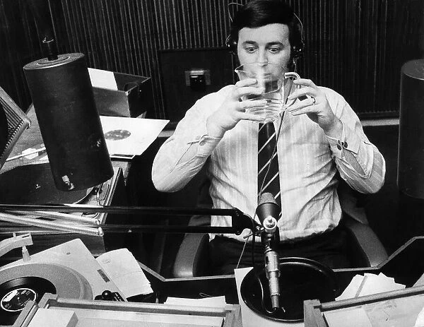 Terry Wogan drinking a jug of water during his record programme on Radio One