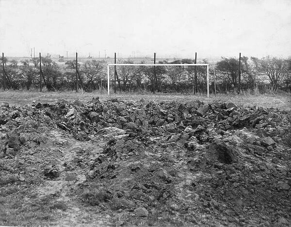 A thirty foot crater caused when a high explosive bomb dropped on a football pitch in