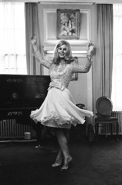 Tina Moore 23, wife of England Captain Bobby Moore, trying on the new dress she will wear