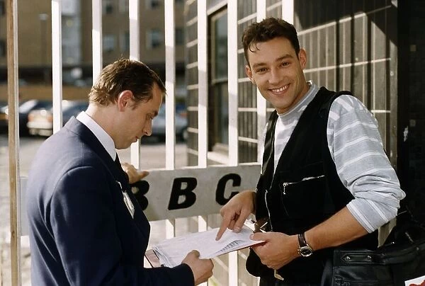 Toby Anstis TV Presenter outside the gates of the BBC with a Security Guard