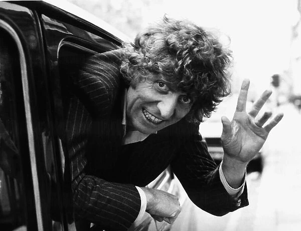 Tom Baker British actor waving from moving taxi cab in November 1980