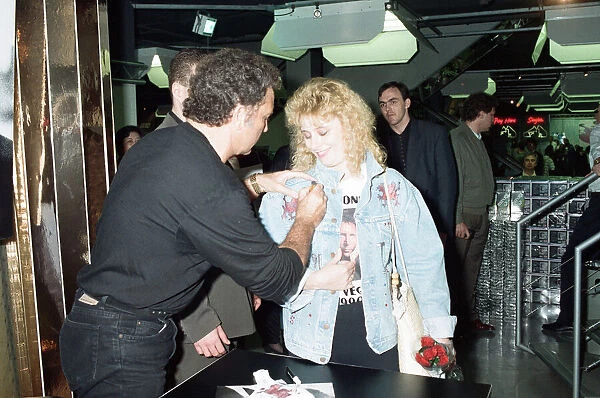 Tom Jones signs the knickers and jacket of his fan Kathy Hall at HMV Oxford Street