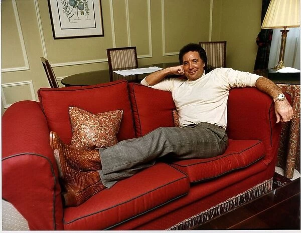 Tom Jones singer lying on a red couch
