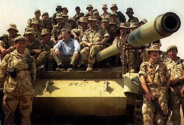 Tom King MP sits on a army tank with a group of soldiers