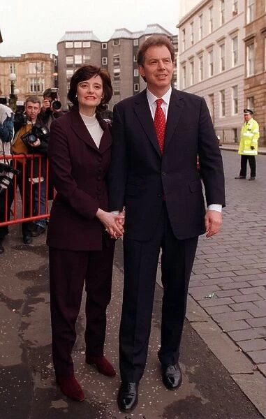 Tony Blair holding hands with wife Cherie while walking through streets of Glasgow 1997