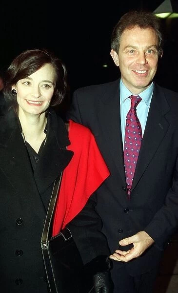 Tony Blair MP in red and blue tie and wife Cherie Blair in black coat with red scarf