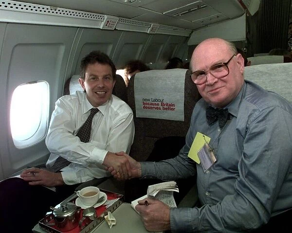 Tony Blair shakes hands with journalist Tom Brown inside aircraft on its way to Edinburgh