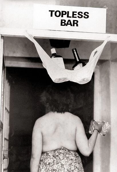 Topless bar sign above a pub door with a bra hooked up holding two bottles of spirits one