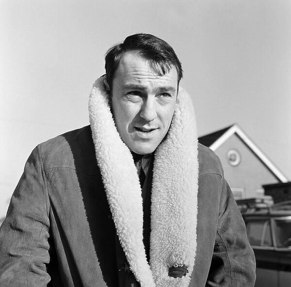 Tottenham and England footballer Jimmy Greaves wraps up against the cold on his way for a