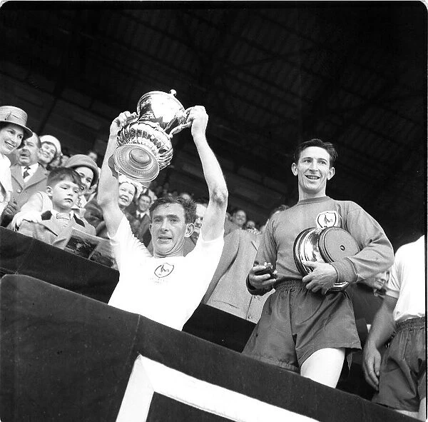 Tottenham Hotspur captain Danny Blanchflower holds the FA cup trophy after their win over