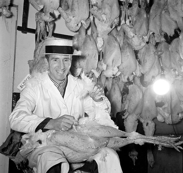 Tottenham Hotspur football player Cliff Jones in a butchers shop. December 1962