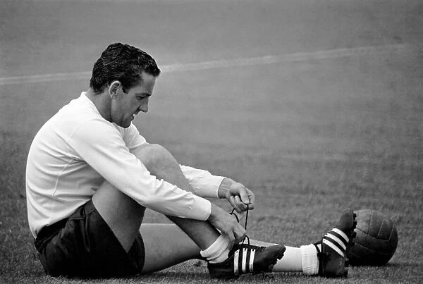 Tottenham Hotspur player Dave Mackay ties up his boot laces during a pre-season training