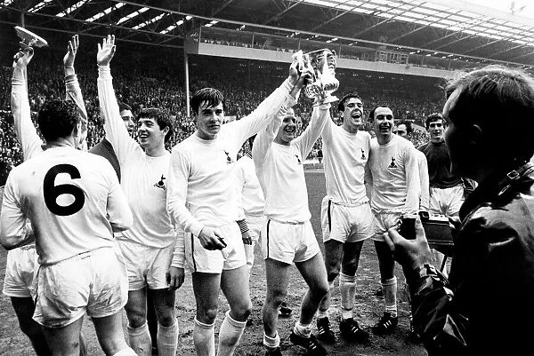 Tottenham Hotspur players celebrate with the FA Cup trophy on the pitch at Wembley after
